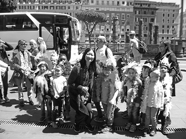 posing with school children who dressed up for the colorful parade in Rome 		width=